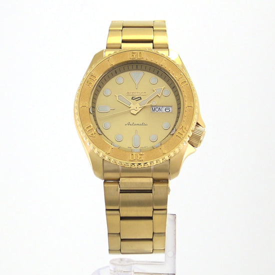 Seiko 5 Sports SRPE74 automatic watch with a metallic gold-tone dial, gold-finished stainless steel case and bracelet, unidirectional rotating bezel, and day-date display.