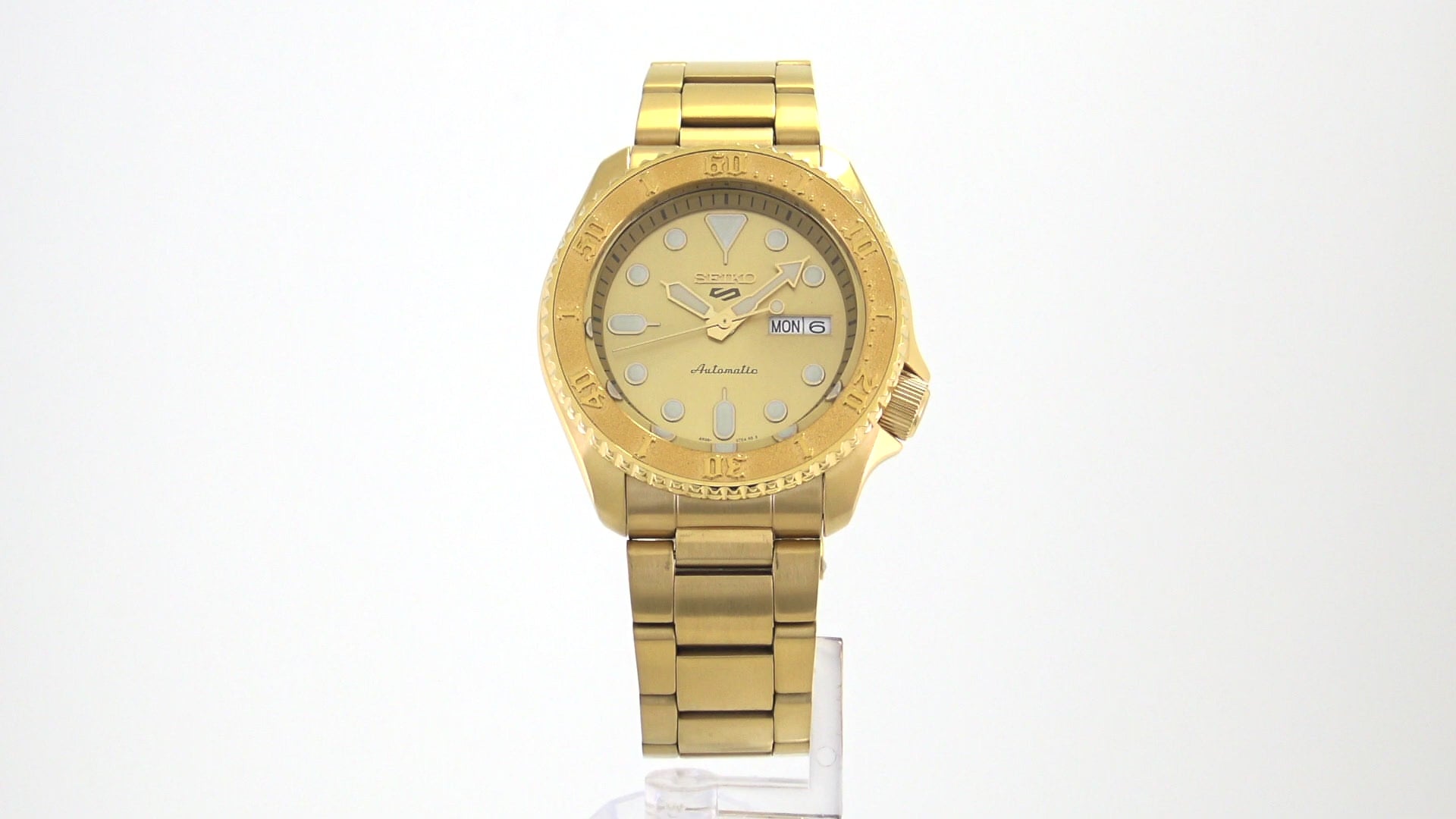 Seiko 5 Sports SRPE74 automatic watch with a metallic gold-tone dial, gold-finished stainless steel case and bracelet, unidirectional rotating bezel, and day-date display.