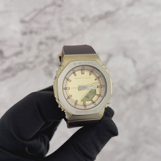 Casio G-SHOCK GMS2110BP-5A women’s analog-digital watch from the beautiful people collaboration, featuring an octagonal 2100 bezel, brown leather-textured bio-based resin band, gold ion-plated bezel, and refined vintage-inspired design.
