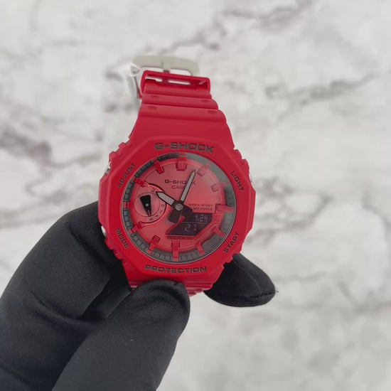 Casio G-SHOCK GA2100RRB-4A analog-digital watch with an octagonal 2100 ‘CasiOak’ design, bold red resin case and band, black accents with inverted LCD, Carbon Core Guard structure, and slim lightweight profile.