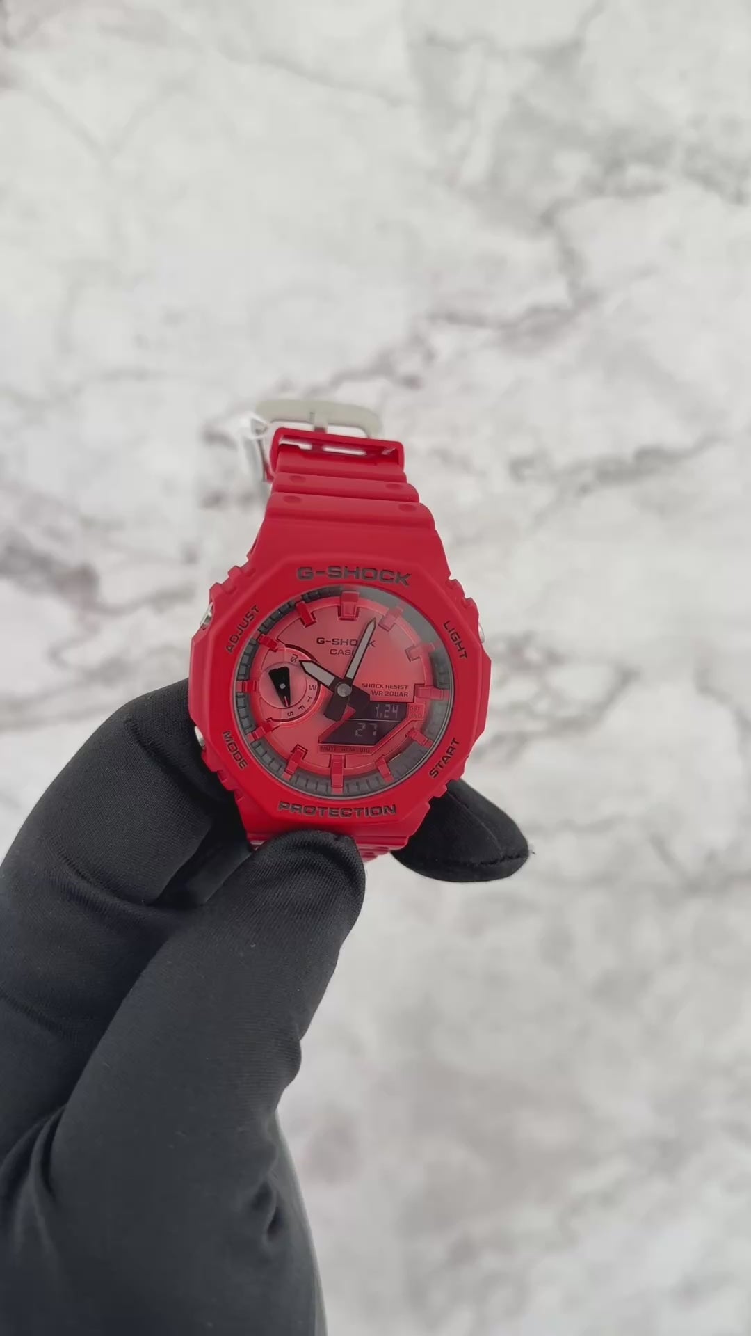 Casio G-SHOCK GA2100RRB-4A analog-digital watch with an octagonal 2100 ‘CasiOak’ design, bold red resin case and band, black accents with inverted LCD, Carbon Core Guard structure, and slim lightweight profile.