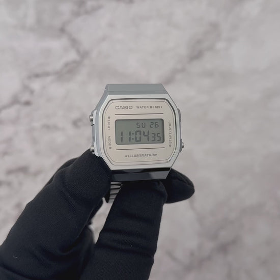 Casio Vintage A168WEM-7VT digital watch with a bright silver-tone stainless steel band, mirror-finish reflective dial, slim 9.6 mm profile, lightweight 49 g body, chrome-plated resin case, mineral glass, EL blue-green backlight, 1/100-second stopwatch, daily alarm, hourly time signal, auto-calendar, and long-lasting 7-year CR2016 battery.