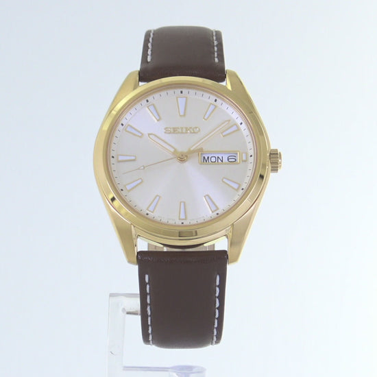 Seiko Essentials SUR450 – elegant gold-tone men’s quartz watch with champagne dial, sapphire crystal, day/date window, and brown leather strap