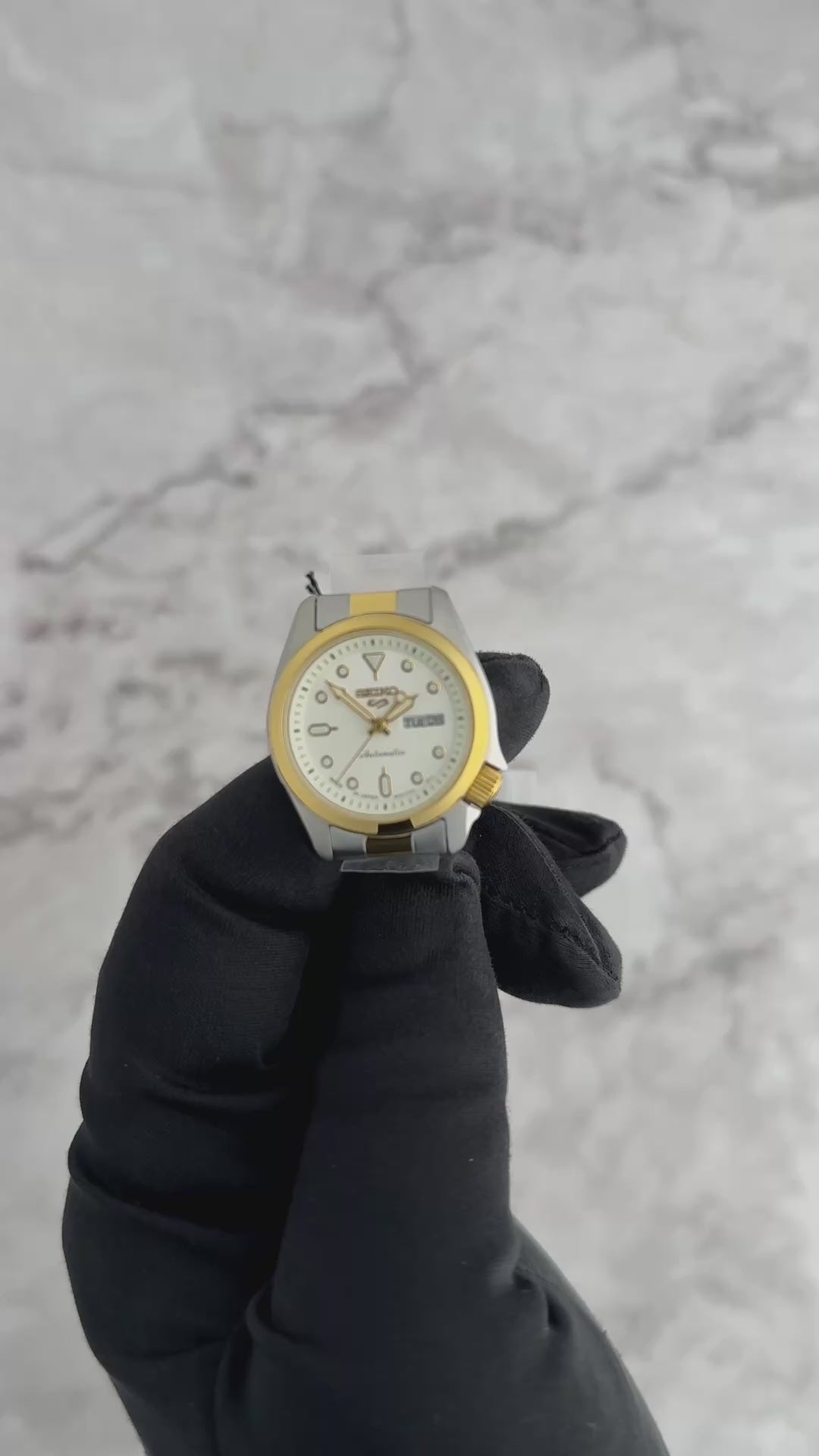 Seiko 5 Sports SRE004 automatic watch with white sunray dial, luminous hands and markers, two-tone stainless steel case and bracelet, and compact vintage-inspired design.